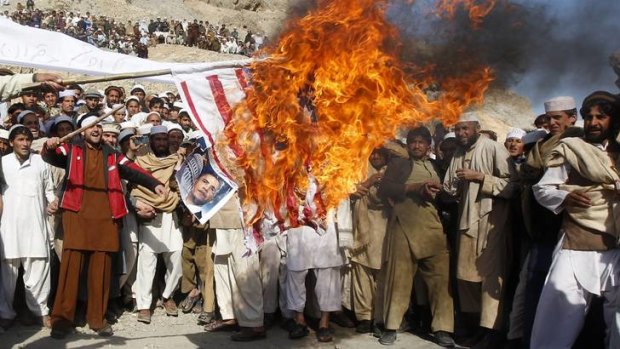 Afghan protesters burn a US flag during a protest in Jalalabad.