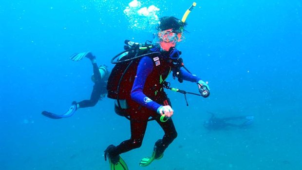 Tina Watson motionless on the seafloor, lower right, as a diver heads to her aid.