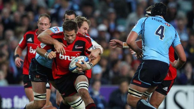 Going down &#8230; the Crusaders' Richie McCaw is tackled by Rocky Elsom of the Waratahs. Sunday’s match at Allianz Stadium, in front of more than 30,000 spectators, was won by the New Zealanders.