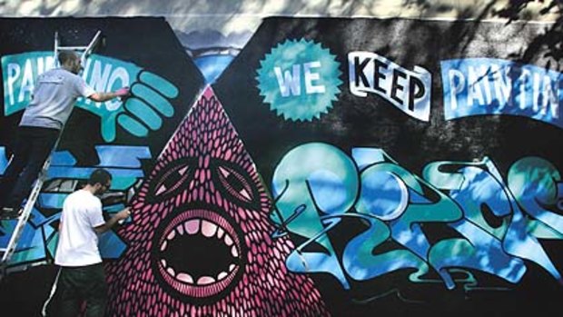 Urban artists ... "Numskull" (left) and "Beastman" paint a legal mural in Surry Hills as a protest against Graffiti Action Day.
