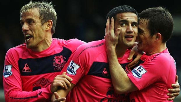 Tim Cahill of Everton celebrates scoring with teammates Phil Neville and Leighton Baines.