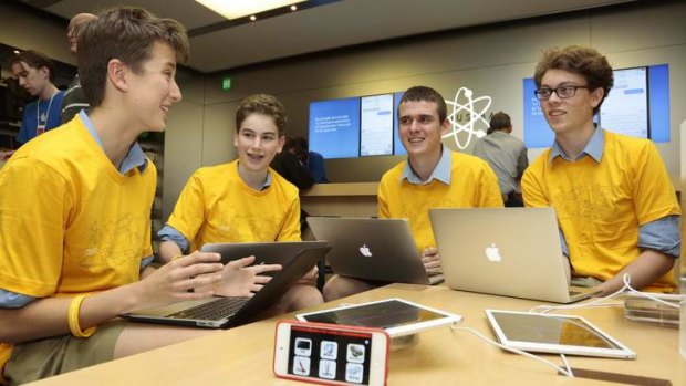 From left, Canberra Grammar School year 8 students Jaxon Kneipp and Damian Camilleri, and year 11 students Josh Whitcombe and Sam Moore during a Code Cadets presentation at the Apple Store; below, staff hand out T-shirts.