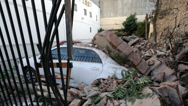 A car is seen under a pile of rubble in Valparaiso in central Chile after an earthquake rocked the country.