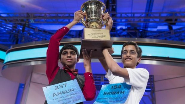 Ansun Sujoe, left, and Sriram Hathwar raise the championship trophy after being named co-champions of America's National Spelling Bee.