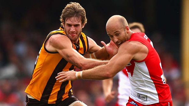 Jarrad McVeigh of the Swans competes for the ball against Grant Birchall of the Hawks.