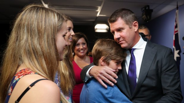 Mr Baird embraces his family after announcing his resignation. 