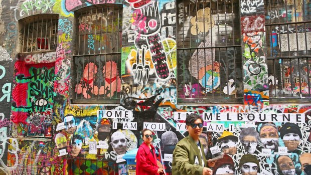 People walk past walls adorned with graffiti in Hosier Lane, one of Melbourne's iconic laneways.