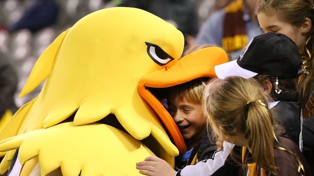 A Hawthorn fan enjoyes being swallowed up by the club mascot during the round 10 match against St Kilda.