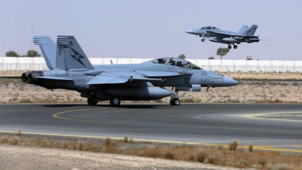All on: A Royal Australian Air Force  F/A-18F Super Hornet takes off as another taxis along the runway as they start their first combat mission over Iraq.