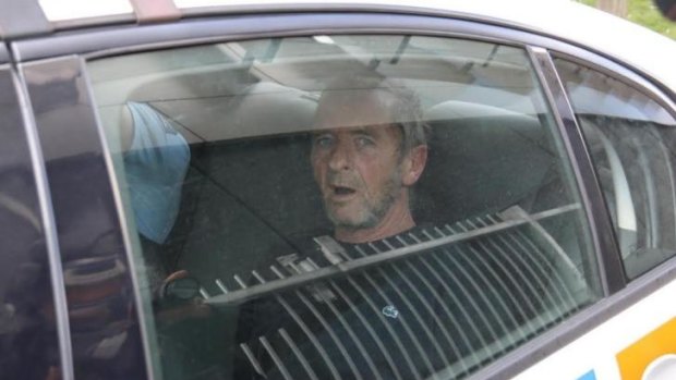 Back in cuffs: AC/DC drummer Phil Rudd is taken away in a police car.