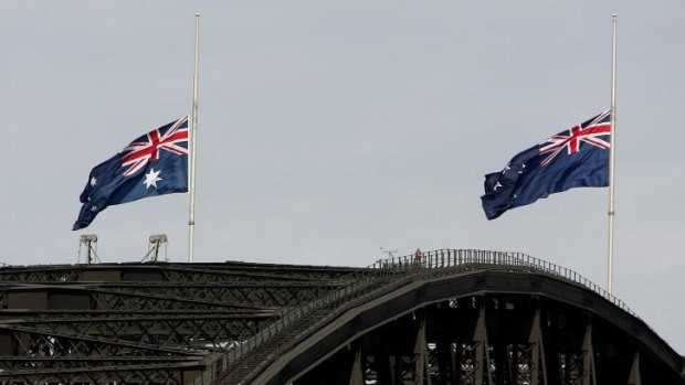 Spot the difference: The Australian (L) and New Zealand flags fly at halfmast on the Sydney Harbour Bridge to commemorate Anzac Day.