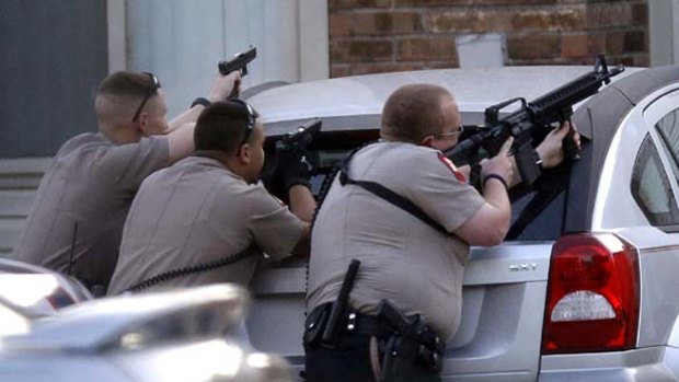 Police aim their guns at an apartment where the suspect was believed to be hiding.