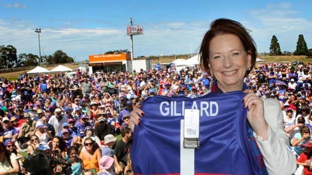 Joint No. 1 ticket holder Julia Gillard shows off the Western Bulldogs jumper she received at Whitten Oval, where she attended the club's family day yesterday.