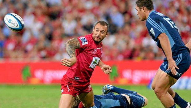 Star man: Quade Cooper gets a pass away under pressure during Friday's match against the Blues in Brisbane.