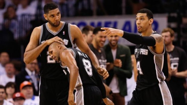 Tim Duncan gives Patrick Mills a congratulatory pat on the head on Sunday.