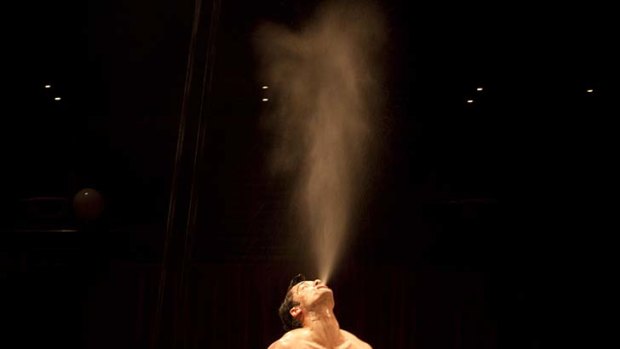 David O'Mer, "Bathboy", hangs above a bathtub at a media call performance for La Soiree at the Sydney Opera House.