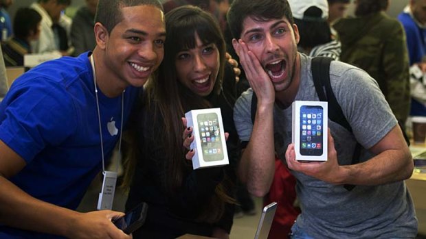 Melisa Racineti and Alejandro de Rosa pose with their new Apple iPhone 5s' at the Apple Store in of Buenos Aires on launch day.