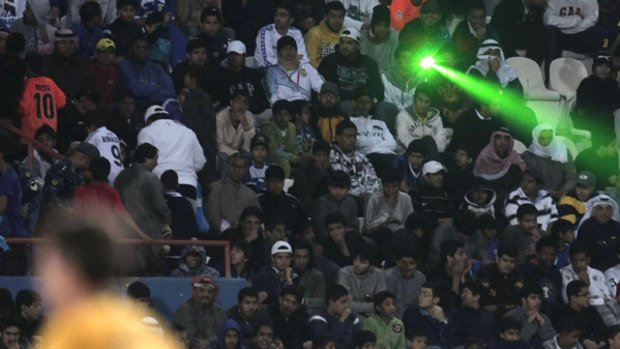 Zapped ... a fan points a laser beam during the match.