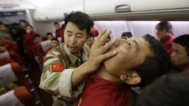Addressing terrorism ... an instructor from the Tianjiao Special Guard Consultant bodyguard training camp pushes a student's jaw as trainees watch him demonstrate close-quarter combat skills during a course on flight safety at a flight attendant training centre near Beijing.