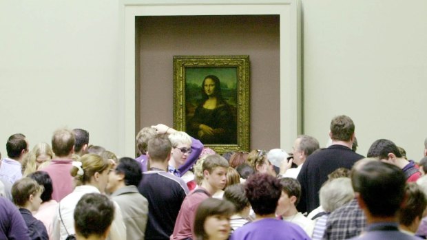 Visitors are packed around the Mona Lisa as they visit the Louvre.