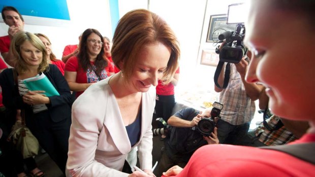 Prime Minister Julia Gillard signs a nures union campaign shirt during a visit to the Melbourne City Mission this morning.