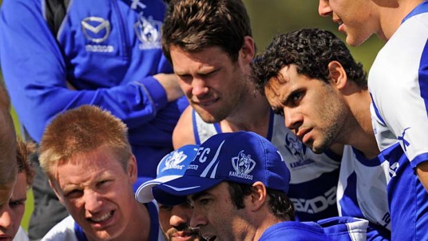 North Melbourne coach Brad Scott explains some moves to his players at training during the week.