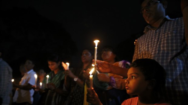 People take part a candle-light vigil to remember the victims of the Gulshan cafe attack.