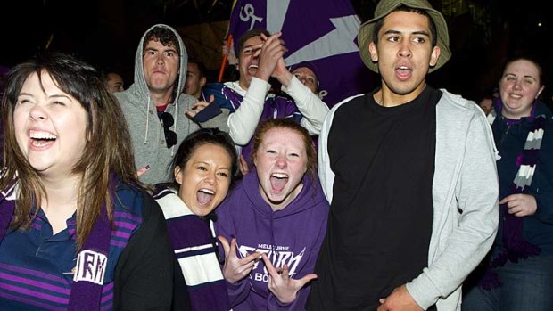 Melbourne Storm supporters celebrate last night after the Storm won the grand final.