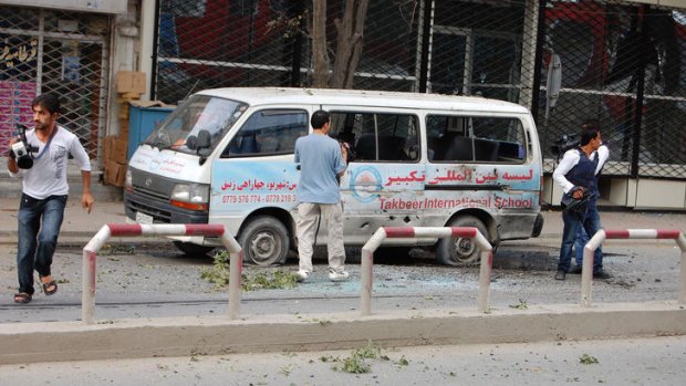 Journalists near a bullet-ridden mini-van during an on-going Taliban attack in Kabul city.