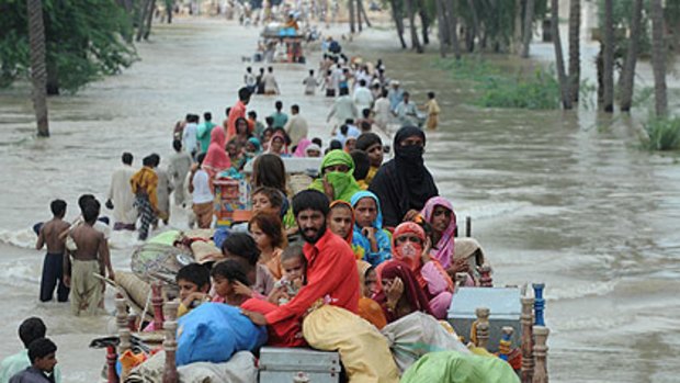 13.8 million affected ... Pakistani flood survivors evacuate a flooded area in Bssera village near Muzaffargarh on August 11.