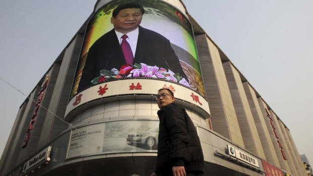 Power transition: A Beijing man walks past a monitor broadcasting a news conference held by Xi Jinping, the general secretary of the Communist Party of China.