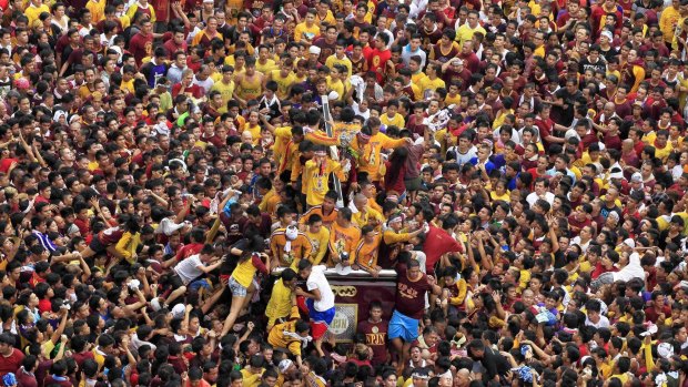 Catholic devotees try to touch the statue of the Black Nazarene as it is pulled on a carriage during an annual procession in Manila last week. More than a million barefoot believers joined the procession, which left two dead and more than 1000 injured.