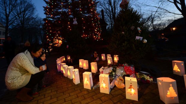 Candles burn at a makeshift shrine to pay tribute to the victims of an elementary school shooting in Newtown, Connecticut.