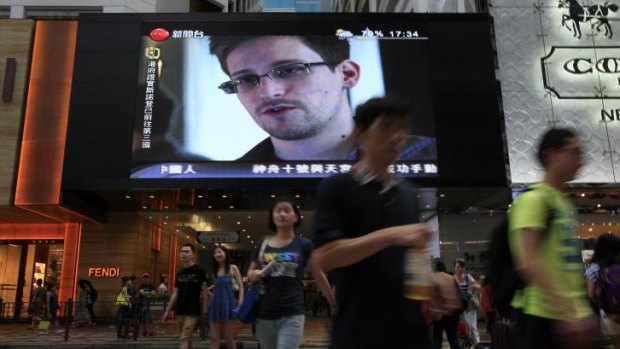A TV screen shows a news report of Edward Snowden, a former CIA employee who leaked top-secret documents about sweeping US surveillance programs, at a shopping mall in Hong Kong.
