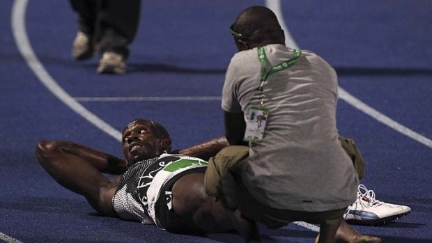 Usain Bolt receives treament on the track after the race.