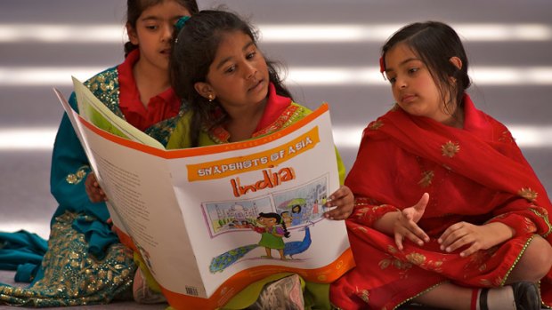 Anika, Iniya and Ruhani, all aged six, study a book about  India for their Hindi class.