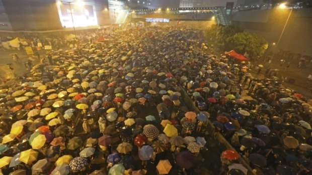 Pro-democracy protesters hold umbrellas under heavy rain in a main street near the government headquarters in Hong Kong.