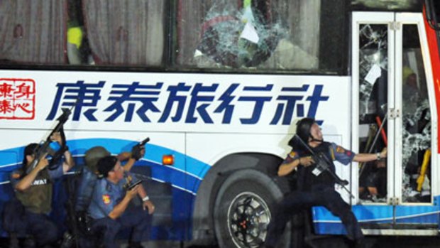 Policemen take position as they start their attack on the hijacked tourist bus.