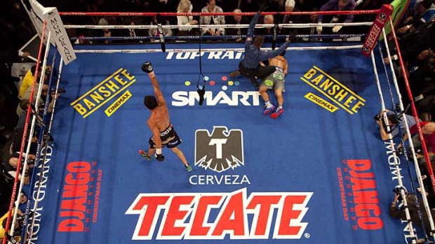 Over and out ... Juan Manuel Marquez, left, celebrates as referee Kenny Bayless calls Manny Pacquiao down for the count.