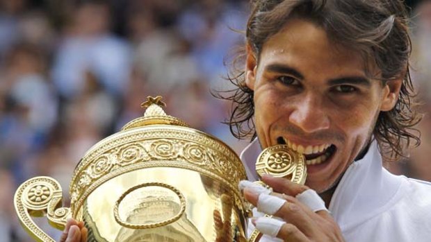 Rafael Nadal bites the Wimbledon trophy.