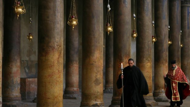 Monks walk through the Church of the Nativity in Bethlehem.
