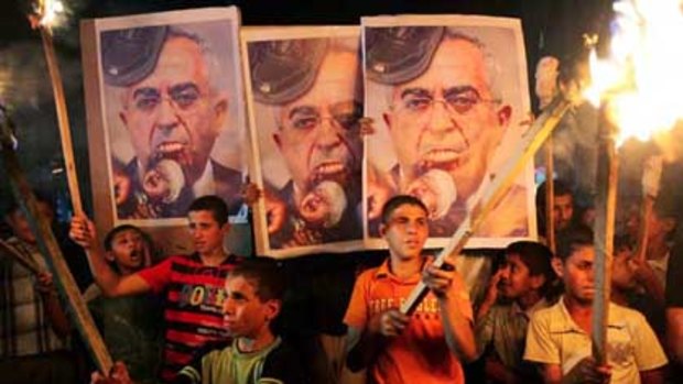 Hamas supporters hold posters of Palestinian Prime Minister Salam Fayyad at a rally over the lack of electricity in Gaza City.
