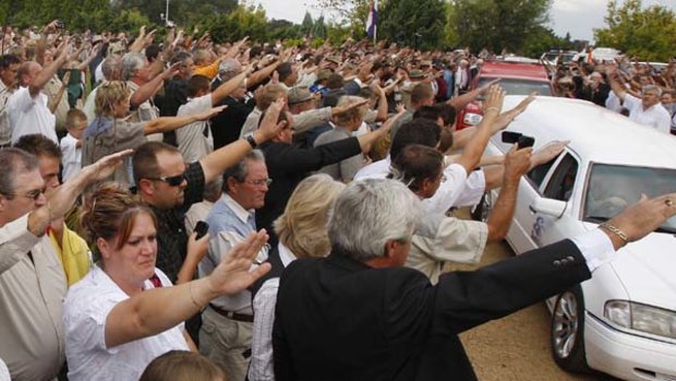 Supporters of slain white supremacist leader Eugene Terreblanche, give a Nazi-style salute to his coffin as it is driven from the church in Ventersdorp, South Africa.