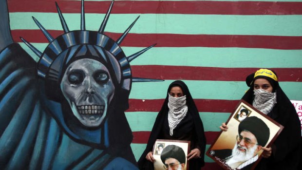 Iranian women hold pictures of Supreme Leader Ayatollah Khamenei outside the former US embassy in Tehran.