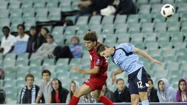Gabriel Fellyppe of Kashima Antlers and Shannon Cole of Sydney FC jump for the ball.