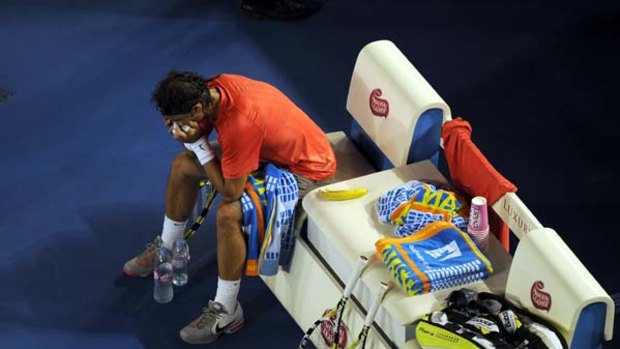 Under pressure ... Rafael Nadal during a break in his straight-sets loss to fellow Spaniard David Ferrer in Melbourne last night.