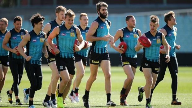 Port Adelaide players warm up before a training session at Adelaide Oval on Saturday.