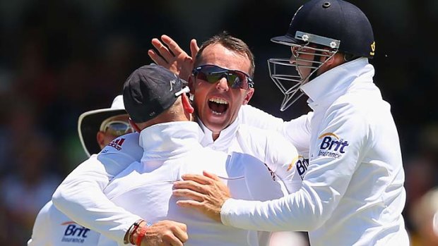 Graeme Swann of England is congratulated by team mates after getting the wicket of David Warner in Perth.