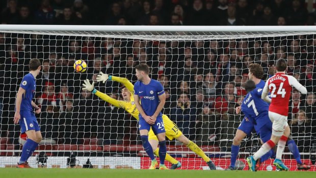 Late drama: Thibaut Courtois dives in vain as Hector Bellerin's shot slams into the net.