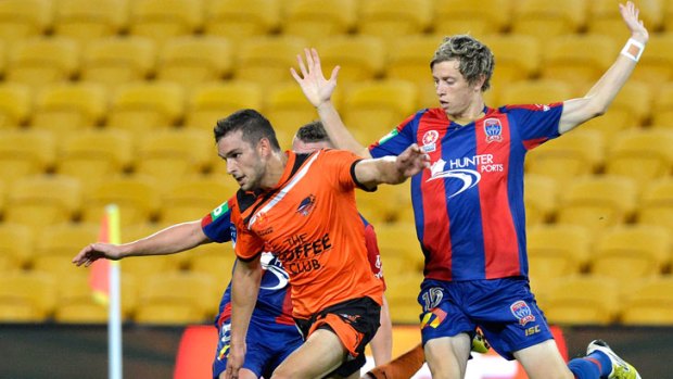 Jack Hingert of the Roar gains a penalty for his team after he is taken down in this tackle by the Jets during the round nine A-League match between the Brisbane Roar and the Newcastle Jets at Suncorp Stadium on December 1, 2012 in Brisbane, Australia.